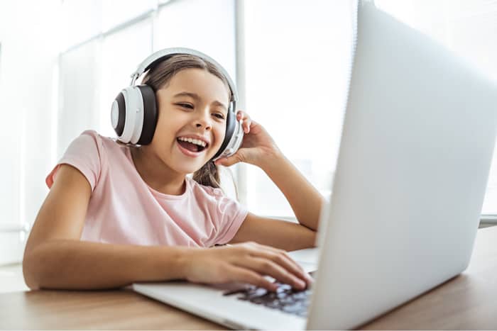 Young girl using laptop with headphones