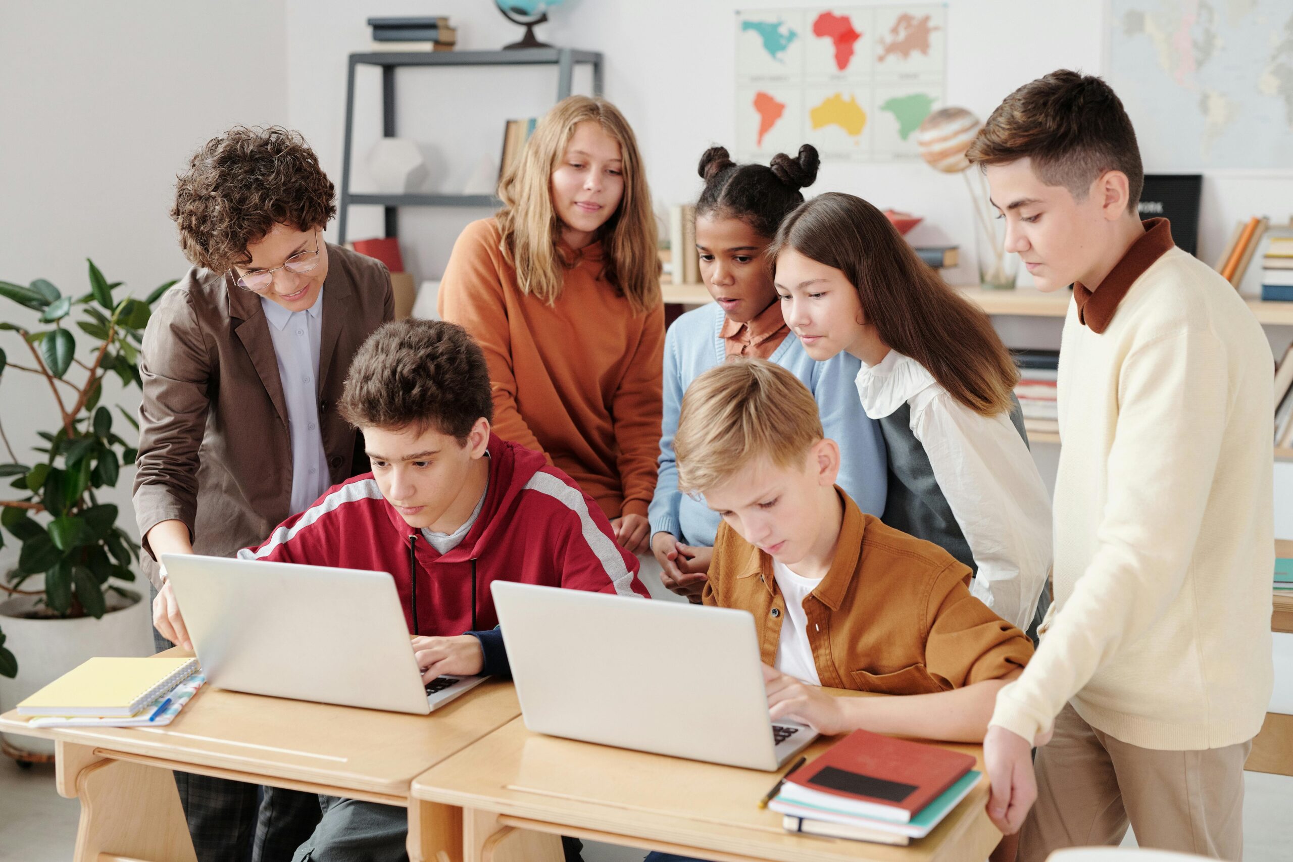 students gathered around two students with computers showing technology can be distracting